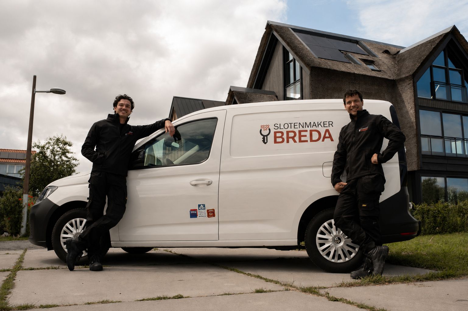 Monteurs van Slotenmaker Breda naast de witte bedrijfsbus